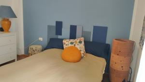 Una cama con una almohada naranja encima. en Tenerife Sweet Home, Cheap and Clean, Pool, Beach, WiFi, Quite, en Los Cristianos