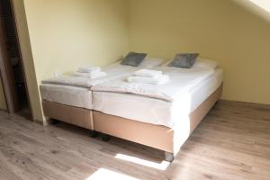 1 dormitorio con 1 cama con sábanas blancas y toallas en TERRA penzión, en Jasová