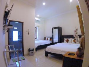 Voodi või voodid majutusasutuse Ndalem Katong Guest House Ponorogo toas