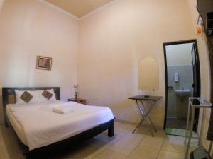 Voodi või voodid majutusasutuse Ndalem Katong Guest House Ponorogo toas
