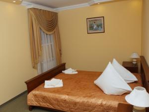 um quarto de hotel com uma cama com toalhas brancas em ВІКОНТ em Chishki