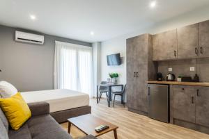 uma sala de estar com uma cama e uma cozinha em Raise Heraklion Boutique Apartments em Iráclio