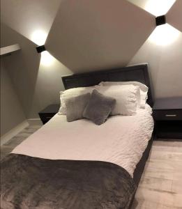 1 dormitorio con 1 cama con sábanas y almohadas blancas en Lisvarna House en Buncrana