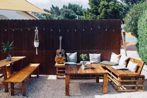 a backyard with a wooden fence with a guitar at The Lighthouse Hostel in Sagres