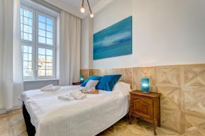 - une chambre dotée d'un lit avec deux bougies bleues dans l'établissement Dom & House - Old Town Mariacka, à Gdańsk