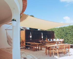 a group of tables and chairs under a canopy at The Lighthouse Hostel in Sagres