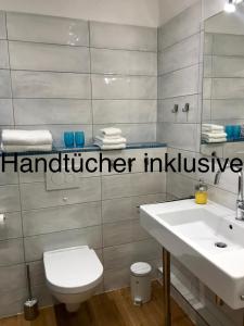 ein Badezimmer mit einem weißen Waschbecken und einem WC in der Unterkunft Moin ! in Timmendorfer Strand + 12 Fotos