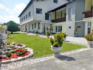 einen Garten vor einem Gebäude mit Blumen in der Unterkunft Alpenblick - Modernes Apartment in Ruhelage in Villach