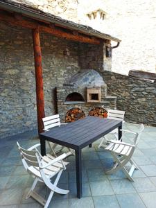 stół i krzesła przed kamiennym piecem w obiekcie casa mauro w Aoście