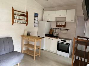 a small kitchen with white appliances and a table at Domek letniskowy Dębki, blisko morza :) in Dębki