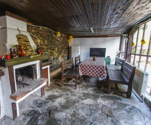 a room with a table and chairs and a fireplace at Guest House Planinska Sreshta in Balkanets