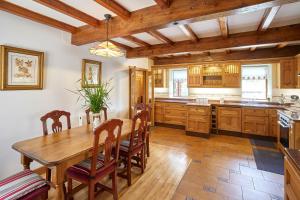 a large kitchen with a wooden table and chairs at Host & Stay - The Cottage Barn in Skipton +10 photos