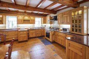 a large kitchen with wooden cabinets and wooden floors at Host & Stay - The Cottage Barn in Skipton