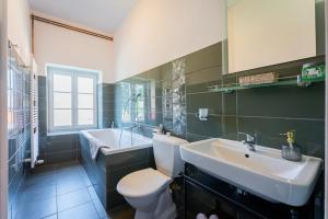 a bathroom with a sink and a toilet and a tub at Penzion U Babky bylinkářky in Kutná Hora