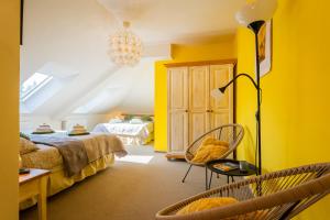 a bedroom with yellow walls and a bed and a lamp at Penzion U Babky bylinkářky in Kutná Hora