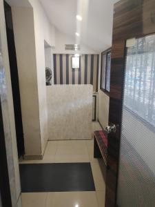 a bathroom with a walk in shower next to a walk in closet at Almas Dormitory Andheri West in Mumbai