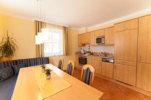 a kitchen with a table and a dining room at Appartements Höller in Kleinarl