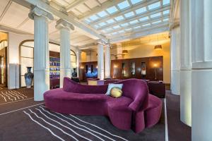 a purple couch in a large room with columns at Hotel Casa Fuster G.L Monumento in Barcelona