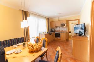 a kitchen and dining room with a table and a television at Appartements Höller in Kleinarl