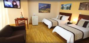 a hotel room with two beds and a couch at Hotel Xilon Resort Pasto in Pasto