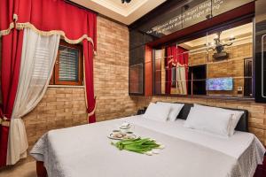 a bedroom with a white bed with a red curtain at Apartment Lav in the City Centre in Kotor