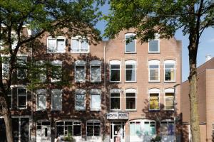 un gran edificio de ladrillo con ventanas blancas en Hostel Ani&Haakien, en Róterdam