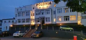 a building with cars parked in front of it at Polonia in Międzyzdroje