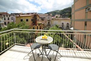 een balkon met een tafel en een fruitschaal. bij SWEET SORRENTO HOLIDAYS in Sorrento