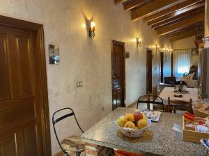 a kitchen with a table with a bowl of fruit on it at Casa Rural Carpintero in Los Santos