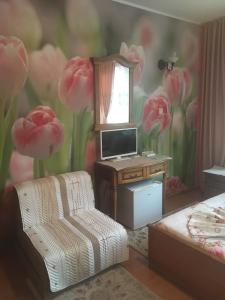 ソゾポルにあるGuest House Hristinaのピンクの花が壁に飾られたベッドルーム1室が備わります。