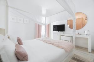een witte slaapkamer met een bed en een spiegel bij Eurostars Florence Boutique in Florence