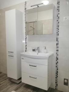 biała łazienka z umywalką i lustrem w obiekcie Apartment Vera, 80 m from the sea w mieście Novigrad