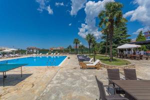- une piscine dans un complexe avec des tables et des chaises dans l'établissement Villa Gloria, à Poreč