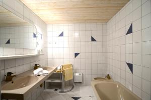 a bathroom with two sinks and a tub and a toilet at Appartementhaus Angerer - Feriendomizile Pichler in Heiligenblut +29 photos