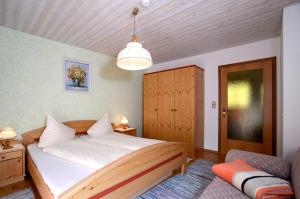 a bedroom with a large bed and a chandelier at Appartementhaus Angerer - Feriendomizile Pichler in Heiligenblut