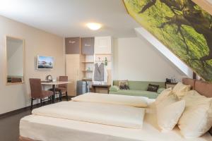 a bedroom with two beds and a table with a chair at Radlhotel Wassertrüdingen in Wassertrüdingen