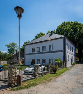 a large white house with a street light in front of it at Penzion U Babky bylinkářky in Kutná Hora