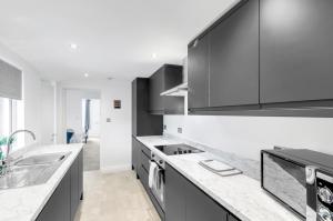 a kitchen with black and white cabinets and a sink at Modern 1bed apartment with parking in Thorpe Saint Andrew