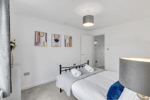Modern 1bed apartment with parking في Thorpe Saint Andrew: غرفة نوم بيضاء مع سرير مع وسادتين