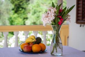 a vase with flowers and fruit on a table at Vuko i Magdalena Midzor in Petrovac na Moru