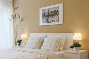 - une chambre dotée d'un lit blanc avec une photo sur le mur dans l'établissement No.4 Apartment Link-To-Happiness, à Klaipėda