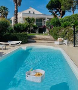 a swimming pool with a basket of food in the water at White Dream Spotorno in Spotorno