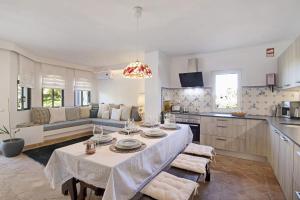 
a kitchen with a table and chairs and a large window at Pedra Mansa Nr 1 in Carvoeiro
