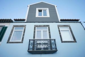 a building with a balcony on the side of it at Largo Bispo Boutique Hostel in Horta