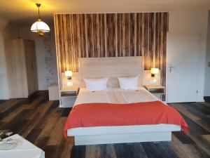 ein Schlafzimmer mit einem großen Bett mit einer roten Decke in der Unterkunft Hotel Up´n Diek in Dangast