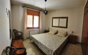 um quarto com uma cama, um espelho e uma janela em Casa Rural Tobal em Castellote