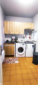 una cucina con piano cottura bianco e lavastoviglie di RESIDENCE CEZANNE a Gréoux-les-Bains