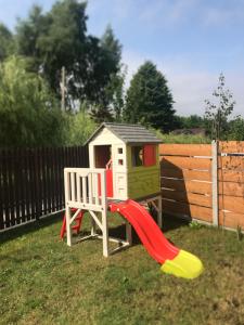 un parque infantil con tobogán y una casa en Pokoje Gościnne Lena, en Święta Katarzyna