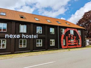 a building with a sign on the side of it at Nexø Modern Hostel. Private Rooms in Neksø