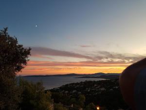 una vista sul tramonto di una città e di un bacino d'acqua di Villa Marcelline Belle vue mer Golfe de Saint Tropez a Saint-Peïre-sur-Mer